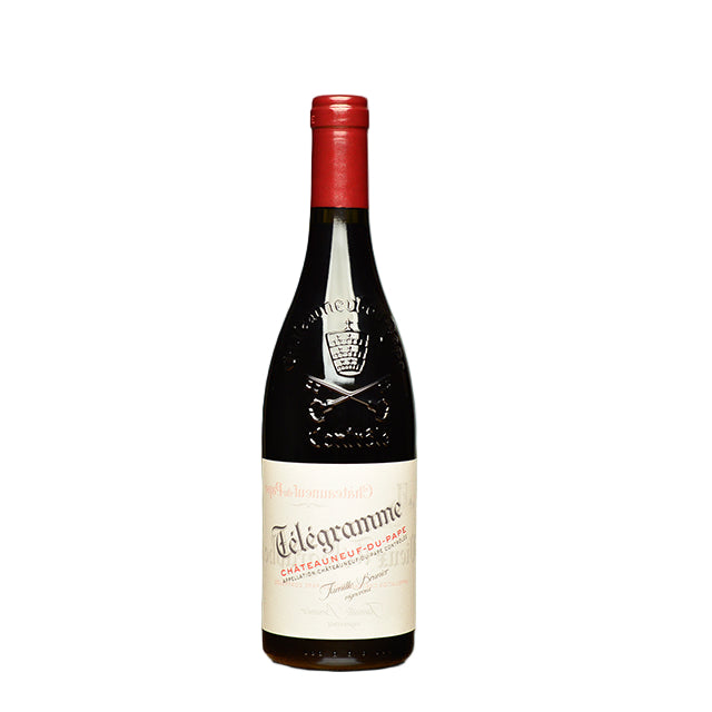 Wine bottle with red cap and visible label on a wooden surface with a blurred background