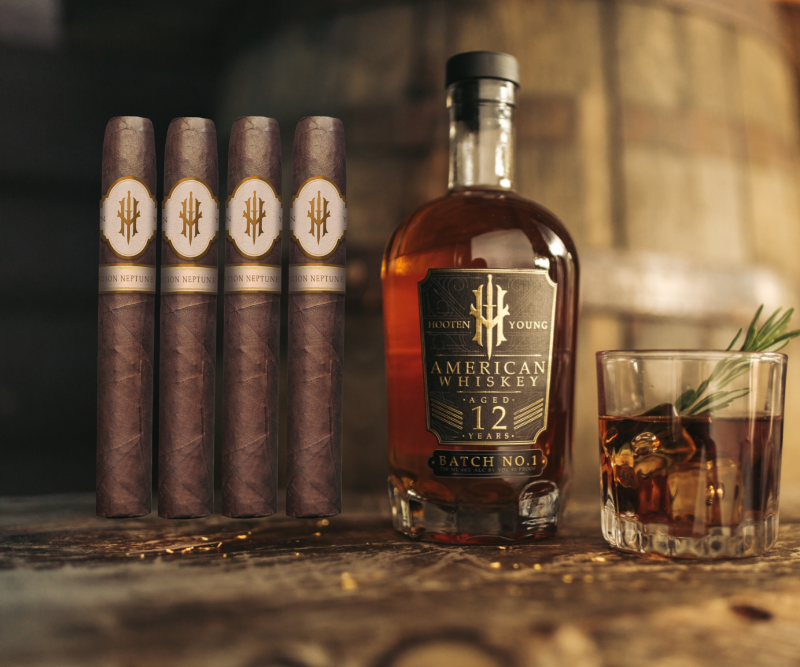 Hooten Young 12 Year American whiskey bottle beside four Operation Neptune Spear Toro cigars and a glass of whiskey on wooden table