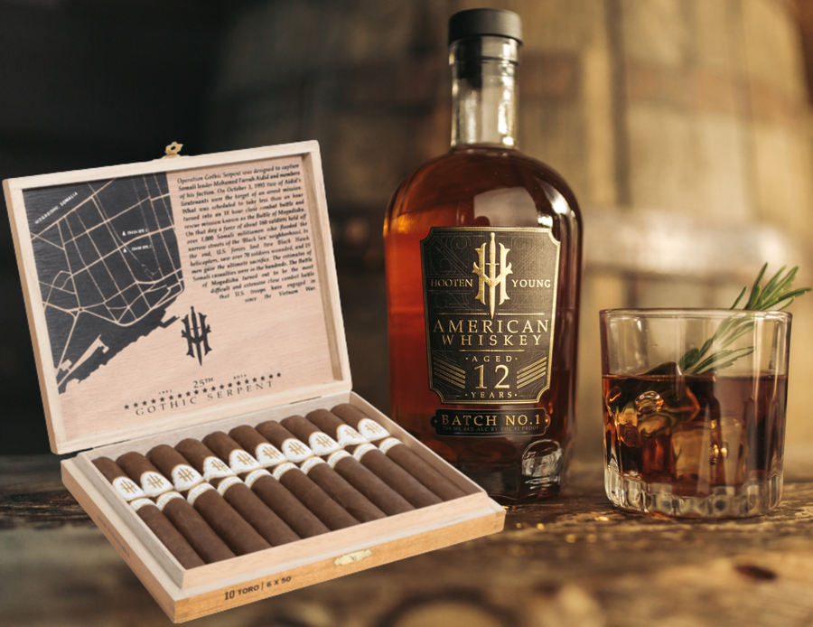 Hooten Young 12 Year 750ML whiskey bottle with Operation Gothic Serpent Torpedo 10 CT cigar box and whiskey glass on wooden table
